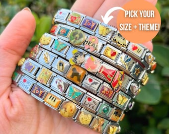 Op de afbeelding: Een zilverkleurige modulaire bedelarmband met diverse kleurrijke emaille en metalen schakels. De schakels tonen uiteenlopende iconen zoals hartjes, dieren, vlinders, muziekinstrumenten en teksten zoals I Love My Girls en I Love My Life.
