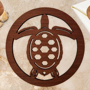 May include: A round, wooden trivet with a turtle design. The trivet is made of dark brown wood and features a cutout turtle silhouette within a circular frame. The background includes an onion, garlic, a wooden spoon, and a white napkin.