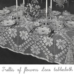 May include: A white crocheted tablecloth with a trellis pattern and floral designs. The tablecloth is set for a formal dinner with plates, silverware, and glasses.