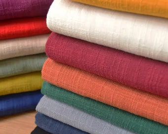 May include: A stack of fabric swatches in various colors, including purple, red, white, burgundy, orange, green, gray, blue, and black. The fabric has a textured, woven appearance.