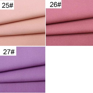 May include: Three fabric swatches in different colors. The top left swatch is a light pink, the top right swatch is a darker pink, and the bottom swatch is a light purple.