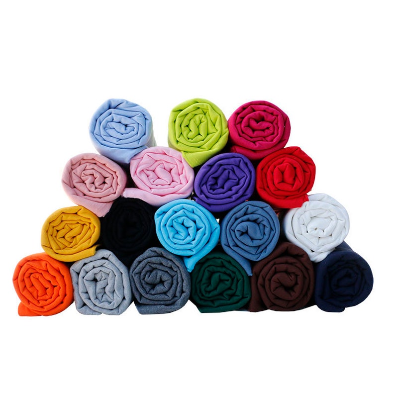 May include: A stack of rolled fabric in various colors, including orange, blue, green, pink, and white. The fabric is arranged in a pyramid shape.