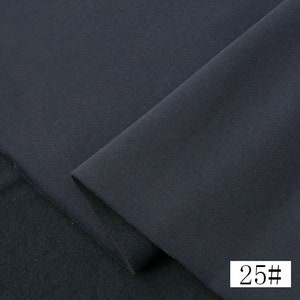 May include: Close-up of a dark gray fabric with a smooth texture. The fabric is folded in half, and the number "25#" is visible in the bottom right corner.