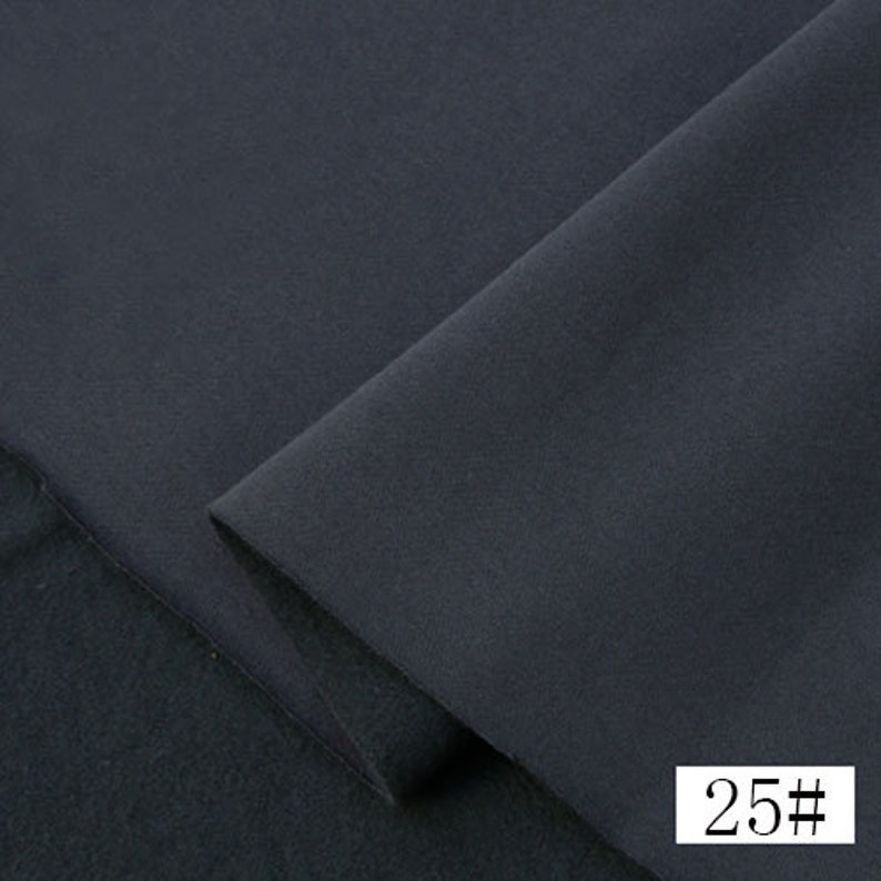 May include: Close-up of a dark gray fabric with a smooth texture. The fabric is folded in half, and the number "25#" is visible in the bottom right corner.