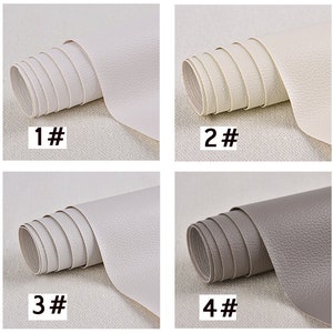 May include: Four rolls of faux leather fabric in different colors. The first roll is white, the second is off-white, the third is light gray, and the fourth is gray. Each roll is labeled with a number from 1 to 4.