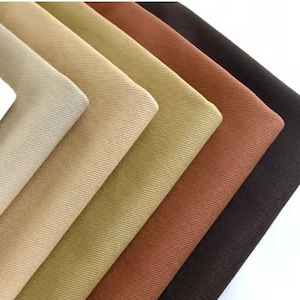 May include: A collection of fabric swatches in various shades of brown, beige, and white. The fabric has a corduroy texture.
