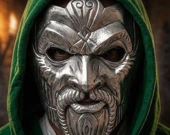 May include: A metallic silver-colored face mask featuring an intricate, sculpted design of a bearded individual with deep-set eye openings. The mask is framed by a vibrant green hood that covers the top and sides of the head, creating a stark contrast.