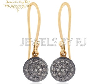 May include: A pair of gold dangle earrings with a round black setting. Each setting is filled with small, white diamonds.