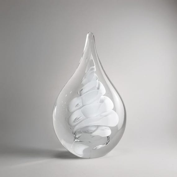 A freeform flat-white blown glass drop sculpture — 104 favorites confirm this minimalist organic form has real visual pull as shelf art.