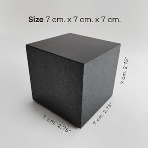Pode incluir: Um cubo preto de granito, medindo 7 cm de cada lado. Tamanho: 7 cm x 7 cm x 7 cm.