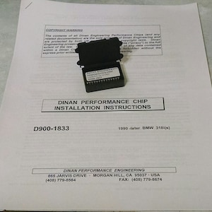 May include: A black and white instruction sheet for installing a Dinan Performance Chip for a 1990 or later BMW 318i. The sheet includes the Dinan Performance Engineering logo and contact information. The sheet also includes the text "D900-1833" and "1990-later BMW 318i(s)".