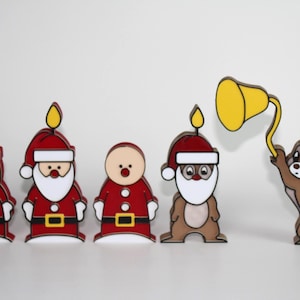 May include: A set of five decorative wooden figures featuring two Santa Clauses with candles on their hats, a round-faced figure in a Santa suit, a chipmunk in a Santa hat with a candle, and a chipmunk holding a yellow bell on a wire.