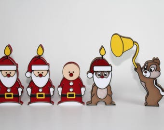 May include: A set of five decorative wooden figures featuring two Santa Clauses with candles on their hats, a round-faced figure in a Santa suit, a chipmunk in a Santa hat with a candle, and a chipmunk holding a yellow bell on a wire.