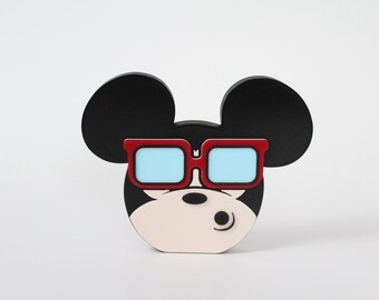May include: A black and white cartoon character with large ears and red sunglasses. The character has a white face with black eyes and a black nose.