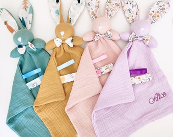 Pretty flat comforter Rabbit swaddle with label, small bow and personalized embroidery of the first name of a mixed baby girl boy