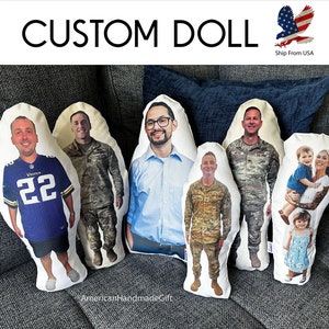 May include: Six custom-made pillow dolls featuring different people. The dolls are made of white fabric with a printed image of a person on the front. The dolls are arranged in a row on a gray couch. The dolls are all different sizes and shapes. The dolls are all wearing different clothes. The dolls are all smiling. The dolls are all looking at the camera. The dolls are all made of soft fabric. The dolls are all handmade. The dolls are all unique. The dolls are all personalized. The dolls are all special. The dolls are all gifts. The dolls are all memories. The dolls are all love.