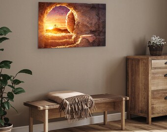 May include: A painting depicting a stone tomb with a large opening, revealing a bright, colorful sunrise with three crosses in the distance. The tomb is empty, with a white cloth lying on the ground.