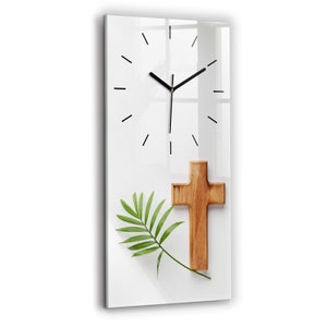 Può includere: Un quadrante di orologio bianco con lancette nere e numeri romani. Una croce di legno e una foglia di palma verde sono posizionate sotto il quadrante dell'orologio.