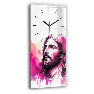 Peut inclure: Une peinture à l'aquarelle de Jésus-Christ sur un fond rose et blanc. La peinture est sur un cadran d'horloge en verre avec des aiguilles noires.