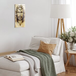 Puede incluir: Un primer plano de una pintura del rostro de Jesucristo. La pintura está en tonos marrones y blancos, y la imagen está enmarcada en un marco de vidrio.