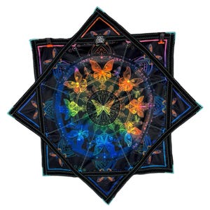 Puede incluir: Pañuelo cuadrado negro con un vibrante diseño de mariposas en colores arcoíris. El pañuelo presenta un patrón circular central con mariposas y el texto "Sick Beets". Los bordes están delineados en negro.