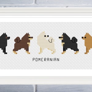 May include: A framed cross-stitch design featuring five Pomeranian dogs in different colours: black, brown, white, black, and brown. The text "Pomeranian" is printed below the dogs.