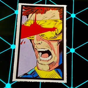 May include: A comic book illustration of a man with yellow goggles and red blood splattered across his face. He is yelling with his mouth open wide.