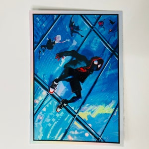 May include: A sticker featuring a comic book character in a black and red suit, swinging from a glass building. The character is wearing a red mask and has a black hoodie. The background is a blue and white cityscape.