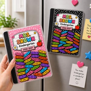 May include: Two rectangular magnets featuring a notebook design with the text MRS. BROWN Kindergarten 2026-2027. One magnet has a pink background with white stars, the other a black background with white stars. Both display colorful crayon graphics with names.