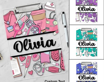 May include: A personalized clipboard with a white background and a colorful design featuring medical-themed illustrations. The clipboard has a silver clip and a black bar with the name "Olivia" written in a cursive font. The design includes a stethoscope, pills, a syringe, a heart, a bandage, and a coffee cup.