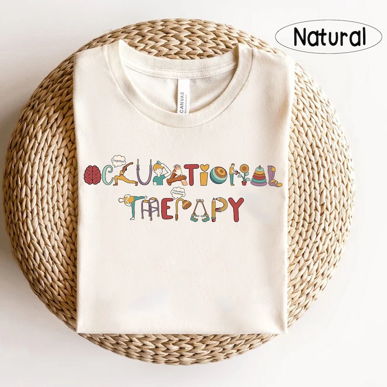 May include: A white t-shirt featuring the text "Occupational Therapy" in colourful letters. Each letter is replaced with a relevant icon, such as a brain, a person doing yoga, a heart, a ball, a tower of blocks, and a shoe.