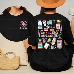 May include: Black t-shirt with a colorful graphic of medical supplies and the text "Emergency Department". The graphic also includes a smaller circle with a pink star of life and the text "Emergency Department Sophia".