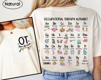 May include: White t-shirt featuring a colourful alphabet chart spelling out "Occupational Therapy Alphabet" with an illustration for each letter. The illustrations depict various concepts associated with occupational therapy. The shirt also displays the text "OT Mrs. Brown" on the front.