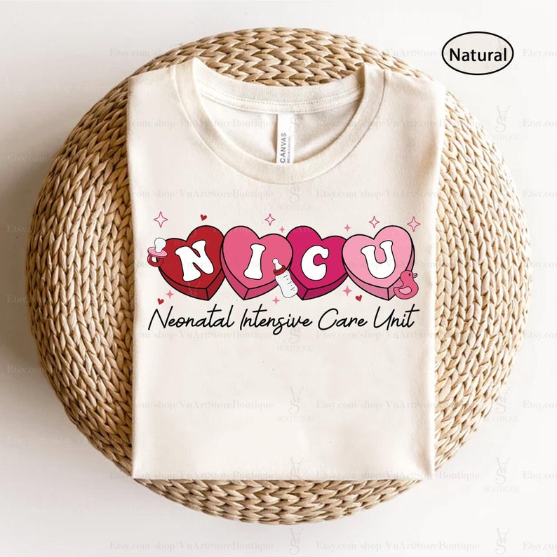 May include: A white t-shirt with a pink and red graphic of the word "NICU" spelled out in hearts with baby-related icons. The text "Neonatal Intensive Care Unit" is printed below the hearts.