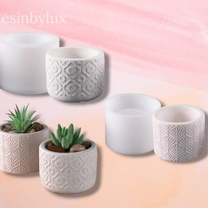 May include: Four silicone moulds for making concrete planters. Two moulds are plain and two have decorative patterns. The patterns are a geometric design and a fan-shaped design.