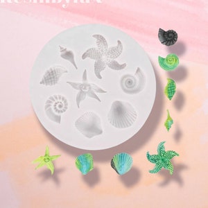 May include: A white silicone mould with 9 different sea-themed shapes, including seashells, starfish, and a nautilus. The mould is surrounded by small, colourful resin castings of the same shapes.