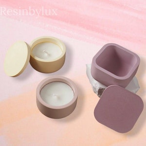 May include: Two sets of candle holders, one set is a pale yellow with a lid and the other set is a pale pink with a lid. Both sets are made of resin and have a simple, modern design.