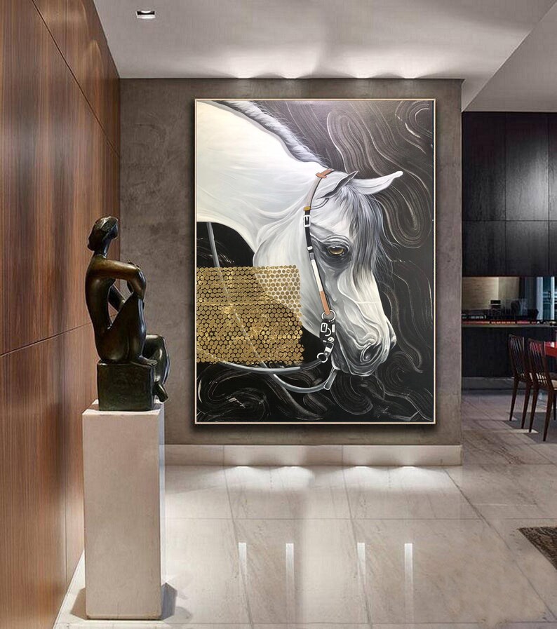 May include: A white horse portrait painting with a gold background. The horse is wearing a bridle and has a black and white striped pattern on its face. The painting is framed and hanging on a wall.