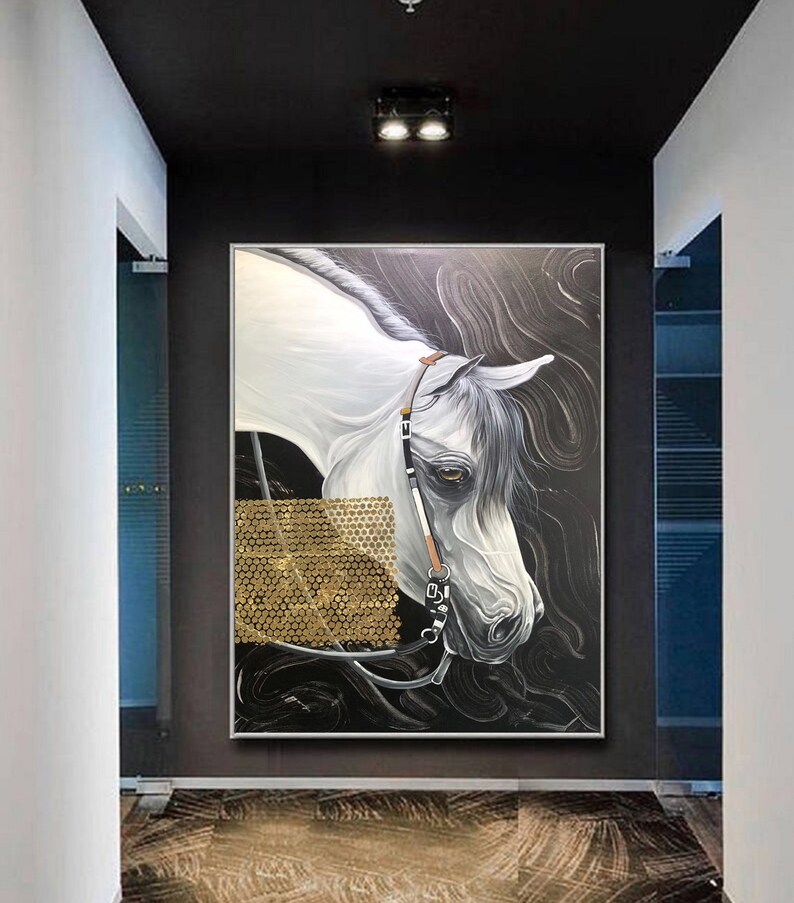 May include: A painting of a white horse with a gold bridle, set against a black background with gold accents. The horse's head is turned to the side, and its eye is visible. The painting is framed in a silver frame.
