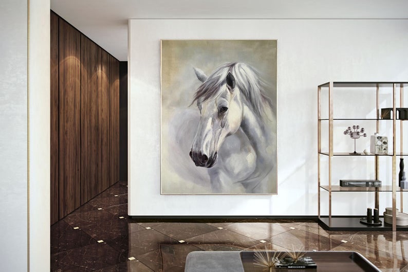Op de afbeelding: Een schilderij van een wit paardenhoofd met een zachte, wazige achtergrond. Het paard heeft een witte manen en staart, en zijn ogen zijn gesloten. Het schilderij is ingelijst in een eenvoudige, witte lijst.