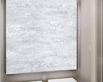 May include: A white abstract painting hangs above two white upholstered benches with metal legs. The benches are on a white and gray chevron patterned floor.
