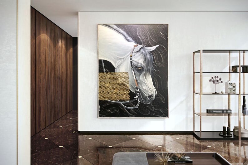 May include: A painting of a white horse's head with a black background. The horse has a golden bridle and is looking to the left. The painting is framed and hanging on a white wall.