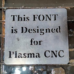 May include: A metal sign with the text "This FONT is Designed for Plasma CNC" cut out of the metal.