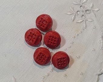 May include: Five red plastic buttons with a square design. The buttons have a raised, woven pattern.