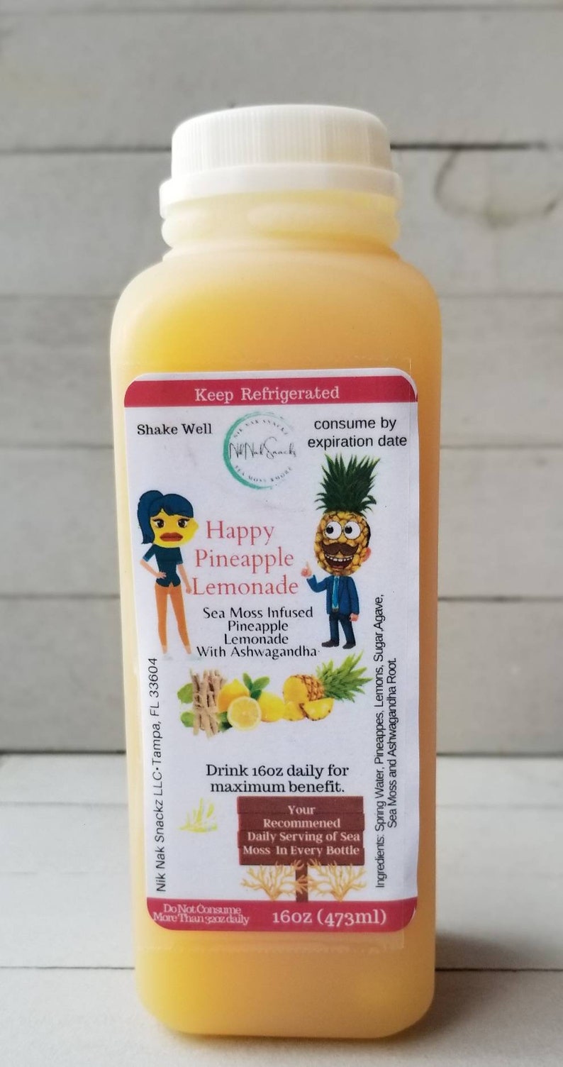 May include: A 16oz bottle of Happy Pineapple Lemonade with a yellow label featuring a cartoon pineapple and a woman. The label says "Sea Moss Infused Pineapple Lemonade with Ashwagandha".