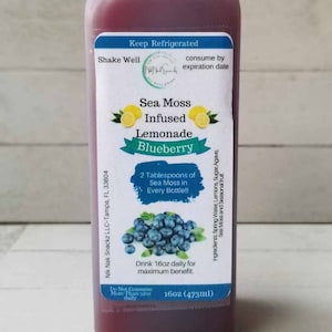 May include: A 473ml bottle of blueberry sea moss infused lemonade. The bottle has a blue label with the words "Sea Moss Infused Lemonade Blueberry" and "2 Tablespoons of Sea Moss in Every Bottle!!".