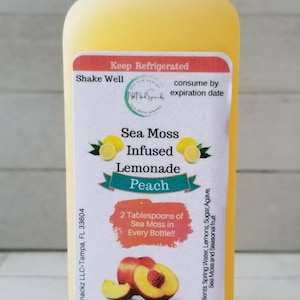 May include: A clear plastic bottle of peach-flavored sea moss infused lemonade. The label reads "Sea Moss Infused Lemonade Peach" and "16oz (473ml)".