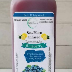 May include: A 16-ounce bottle of blueberry sea moss infused lemonade. The bottle has a white label with the text "Sea Moss Infused Lemonade Blueberry" and "2 Tablespoons of Sea Moss in Every Bottle!!". The label also includes instructions to drink 16 ounces daily for maximum benefit.