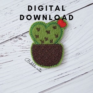 Può includere: Un'applicazione di cactus in feltro in un vaso marrone, con le parole "DOWNLOAD DIGITALE" in alto. Il cactus è verde con dettagli marroni e un piccolo fiore rosso. Il testo "Bobble cute" è scritto in corsivo in basso.