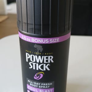 Op de afbeelding: Zwarte Power Stick all-day fresh bodyspray met een Cool Blast geur. De bus heeft een zwart geribbeld ontwerp met een paarse band met de tekst "3.5 oz BONUS SIZE". Netto gewicht: 99g.